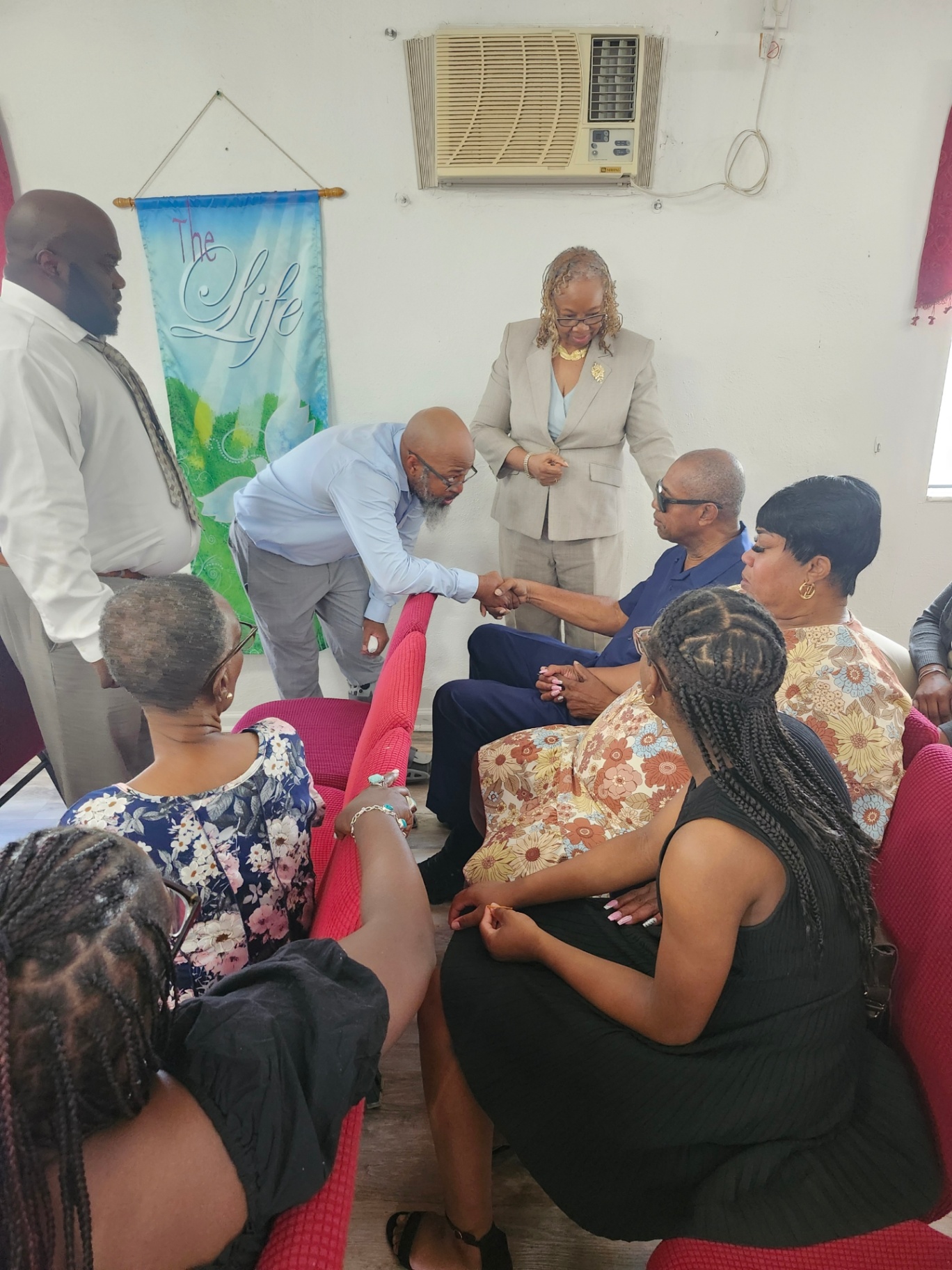Church members joining hands in prayer for one another
