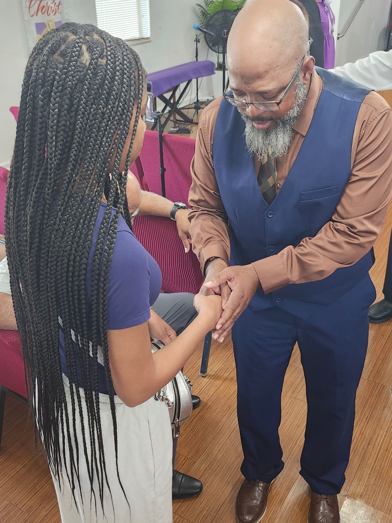 A minister praying with a young member of the congregation